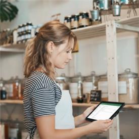 Young woman, working in cafe, uses tablet for work.