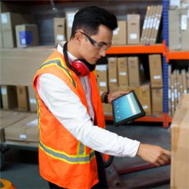 Warehouse operative uses productivity tablet for stock check.