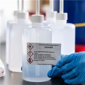 Warning label for hazardous label being applied to chemical container.